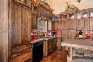Kitchen featuring glass insert cabinets, dishwasher, tasteful backsplash, and dark wood-style floors