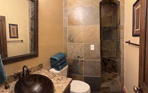Full bath with a textured wall, vanity, and walk in shower
