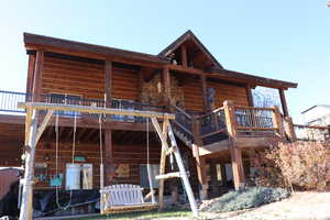 Rear view of property featuring a deck and a patio area