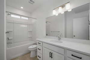 Full bath with bathtub / shower combination, vanity, light tile patterned floors, and recessed lighting