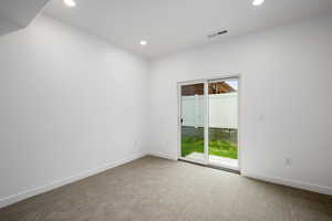 Carpeted empty room with recessed lighting and baseboards