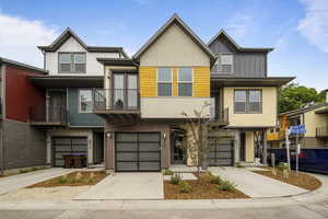 Modern home with concrete driveway, a balcony, an attached garage, brick siding, and stucco siding