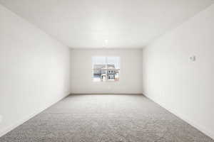 Carpeted spare room with baseboards