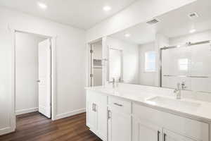 **DISCLAIMER- exterior and interior options will vary**Bathroom featuring double vanity, dark wood-type flooring, recessed lighting, and a shower stall