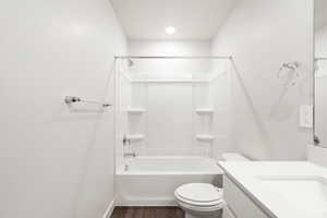 Full bathroom with  shower combination, vanity, and dark wood-style flooring