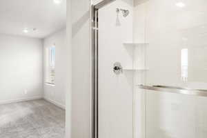 Bathroom with a stall shower, light colored carpet, and recessed lighting