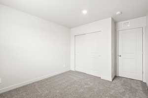 Unfurnished bedroom featuring carpet flooring, a closet, and recessed lighting