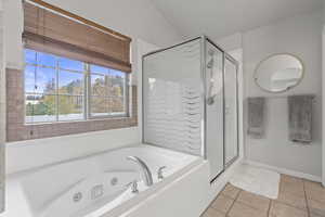 Bathroom with light tile patterned floors, a jetted tub, and a stall shower