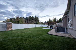 Fenced backyard featuring a patio area, a deck, stairs, and view of scattered trees