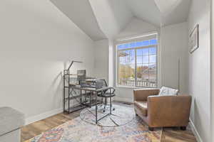 Home office with wood finished floors and lofted ceiling