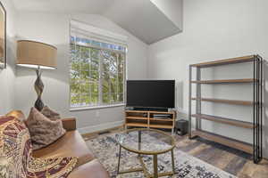 Living area with wood finished floors and vaulted ceiling