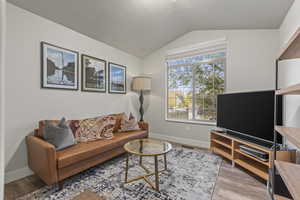 Living area with lofted ceiling and light wood finished floors