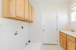 Washroom with cabinet space, washer hookup, electric dryer hookup, and hookup for a gas dryer