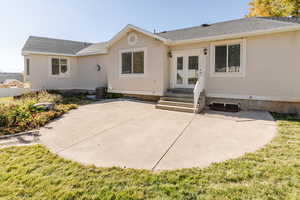 Rear view of house featuring a patio, stucco siding, roof with shingles, and french doors