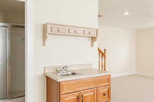Kitchen with light countertops, light colored carpet, a textured ceiling, and light brown cabinetry