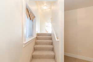 Staircase featuring a textured ceiling