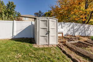 View of shed featuring a fenced backyard and a vegetable garden