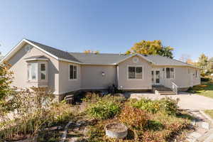 Ranch-style house with a shingled roof and stucco siding