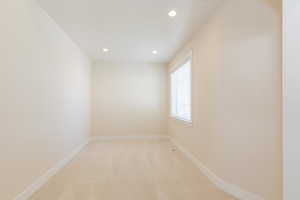 Unfurnished room with light colored carpet and recessed lighting