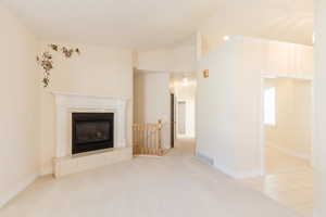 Unfurnished living room with light carpet, vaulted ceiling, a fireplace, recessed lighting, and light tile patterned floors