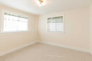 Carpeted empty room featuring baseboards