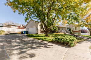 Single story home with driveway, brick siding, and a garage