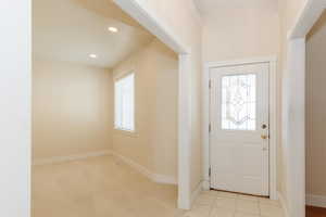 Foyer entrance featuring recessed lighting, light carpet, and light tile patterned floors