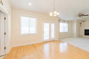 Entryway featuring healthy amount of natural light, wood-type flooring, a chandelier, a ceiling fan, and recessed lighting