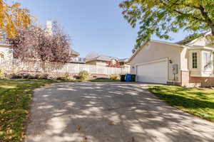 View of home's exterior featuring brick siding, stucco siding, and concrete driveway