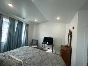 Bedroom with vaulted ceiling and recessed lighting