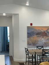 Dining space with wood finished floors and lofted ceiling
