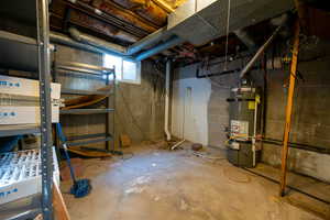 Basement featuring strapped water heater