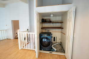 Washroom featuring washer / clothes dryer and wood finished floors