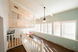 Stairway featuring beamed ceiling, wood finished floors, a ceiling fan, and high vaulted ceiling