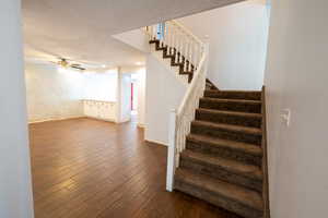 Staircase featuring wood finished floors and ceiling fan