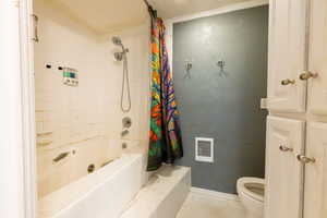 Full bathroom with a combined bath / shower with jetted tub and tile patterned floors