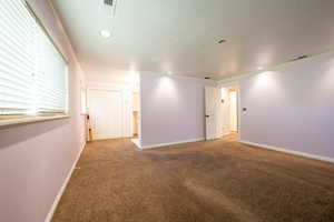 Unfurnished primary bedroom featuring carpet flooring, ornamental molding, and recessed lighting