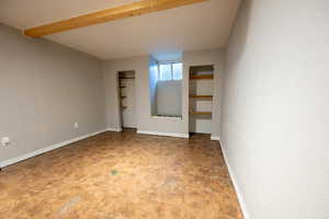 Unfurnished bedroom with a closet and beam ceiling