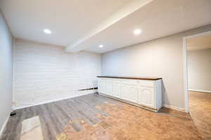 Spare room featuring recessed lighting, light wood-type flooring, and beamed ceiling