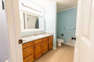 Bathroom with vanity, a textured ceiling, light tile patterned floors, curtained shower, and crown molding