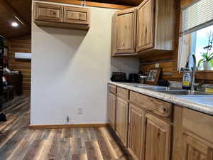 Kitchen featuring light wood finished floors, light countertops, brown cabinetry, and vaulted ceiling