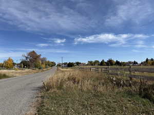 View of asphalt road with a view of rural / pastoral area