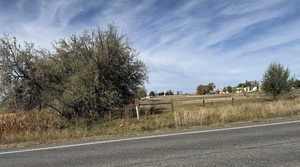 View of asphalt road featuring a view of rural / pastoral area