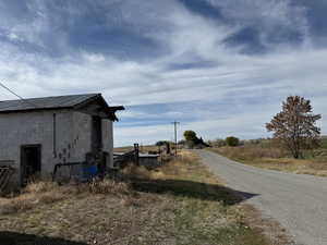 View of asphalt street featuring a view of rural / pastoral area