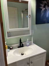 Bathroom with vanity and a shower with shower door