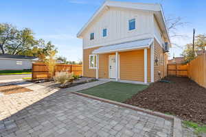 Back of house featuring board and batten siding, a fenced backyard, and a metal roof