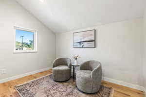 Sitting room featuring vaulted ceiling and light wood-style floors
