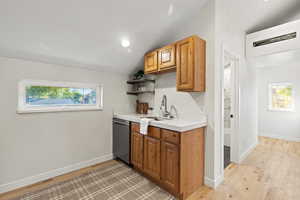 Kitchen with light countertops, vaulted ceiling, light wood-type flooring, plenty of natural light, and open shelves