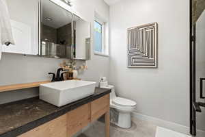 Full bath with vanity, a shower with door, and light tile patterned floors