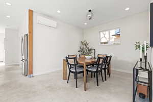Dining area featuring recessed lighting, concrete floors, and a wall mounted AC